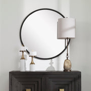 Uttermost Belham round iron wall mirror with black finish, featuring a sleek, modern design and a sturdy metal frame.