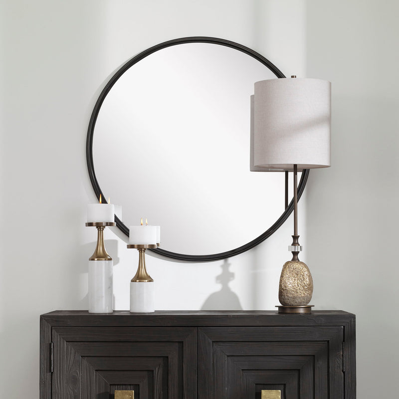 Uttermost Belham round iron wall mirror with black finish, featuring a sleek, modern design and a sturdy metal frame.
