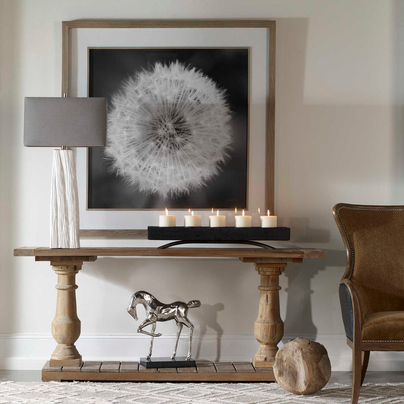 Framed print of dandelion seedhead in black frame by Uttermost, showcasing detailed botanical artwork on a neutral background.