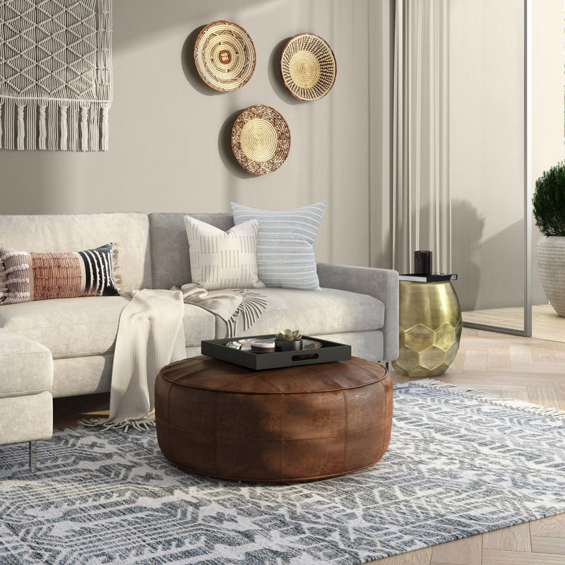 Handcrafted round accent pouf by Simpli-Home with soft fabric upholstery and plush filling, perfect for living room decor.
