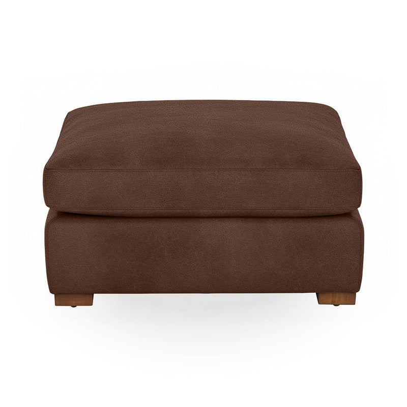 Classic Home Audrey upholstered ottoman with plush fabric and wooden legs, serving as a stylish footrest or accent piece.