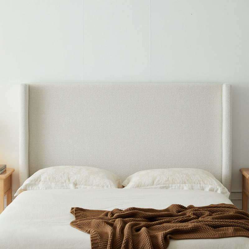 House & Home Furniture Hosford minimalist upholstered wingback bed with wooden platform base, showcasing a modern, upholstered design.
