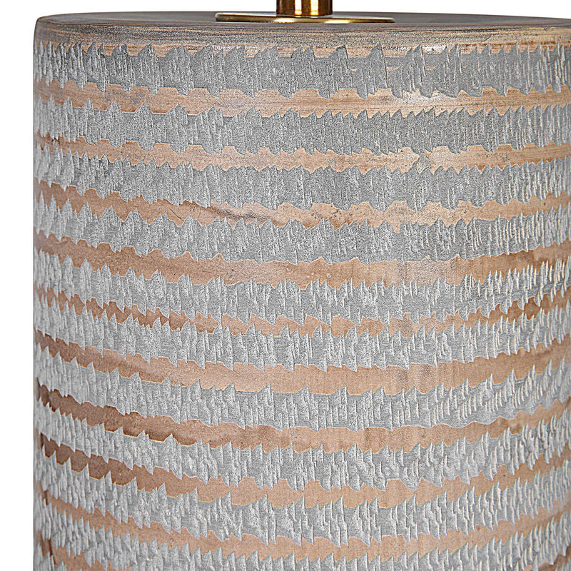 Gray Monolith table lamp by Uttermost with a sleek, modern design and a cylindrical base on a neutral surface.