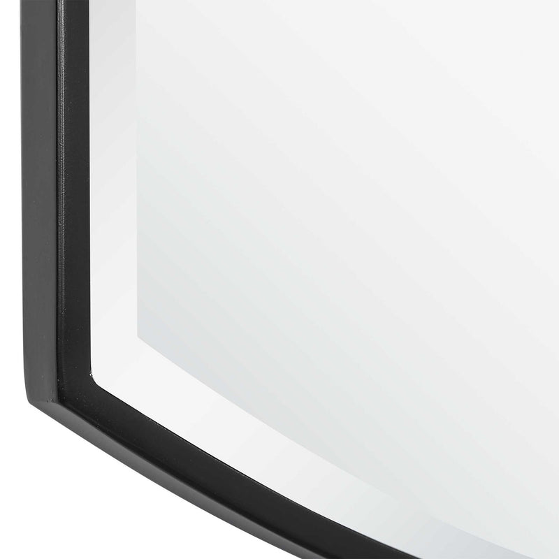 Black shield-shaped iron wall mirror by Uttermost with a bold, artistic design and reflective glass surface.