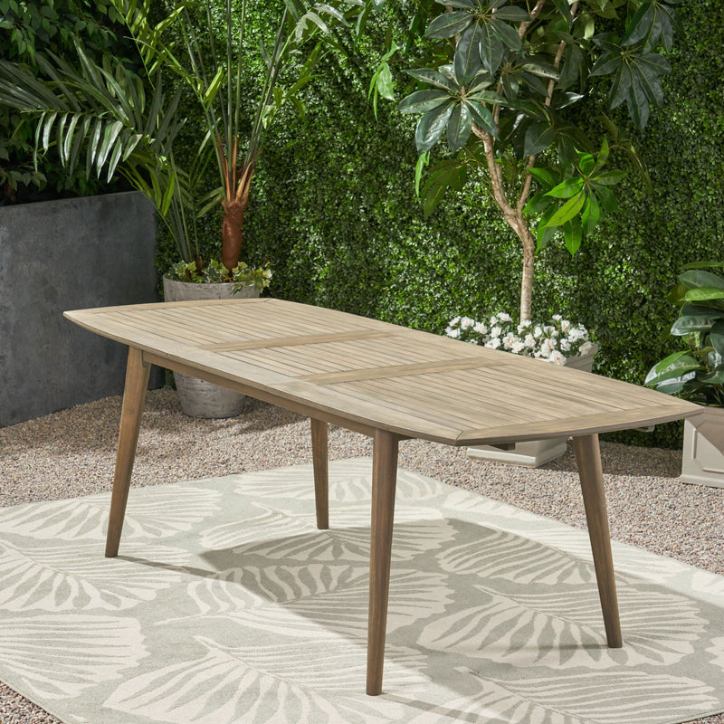Noble House Placidity outdoor expandable dining table with slatted tabletop and tapered legs, perfect for patio dining.