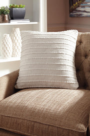 Theban throw pillow from Signature Design by Ashley features a soft fabric cover with decorative stitching, perfect for living room decor.