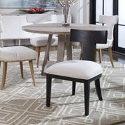 Uttermost Idris armless side chair with plush upholstery and sleek wooden legs, modern design for living or dining room.