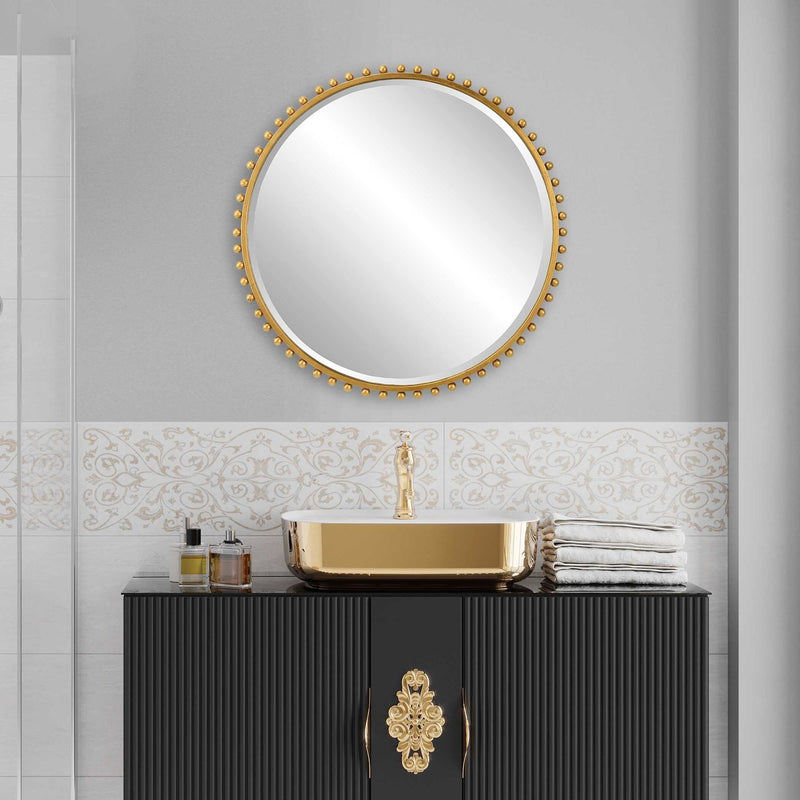 Round iron wall mirror by Uttermost featuring a sleek, minimalist design with a smooth metal frame.