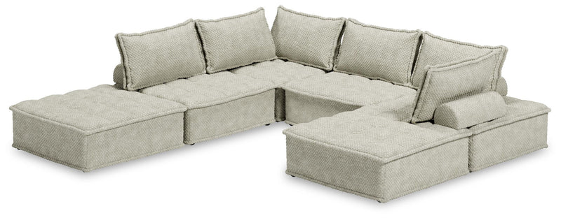 Signature Design by Ashley stationary sectional sofa with beige fabric and plush cushions in a modern living room setting.