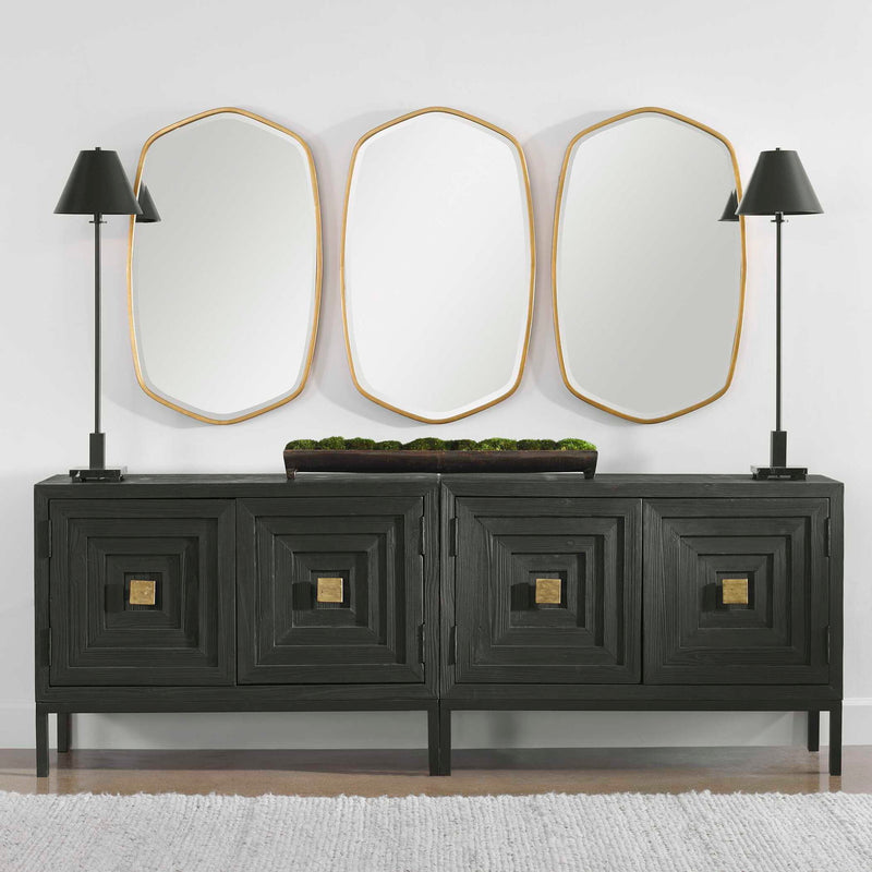 Uttermost Duronia iron wall mirror with sleek, modern frame reflecting light and adding contemporary style to a room.