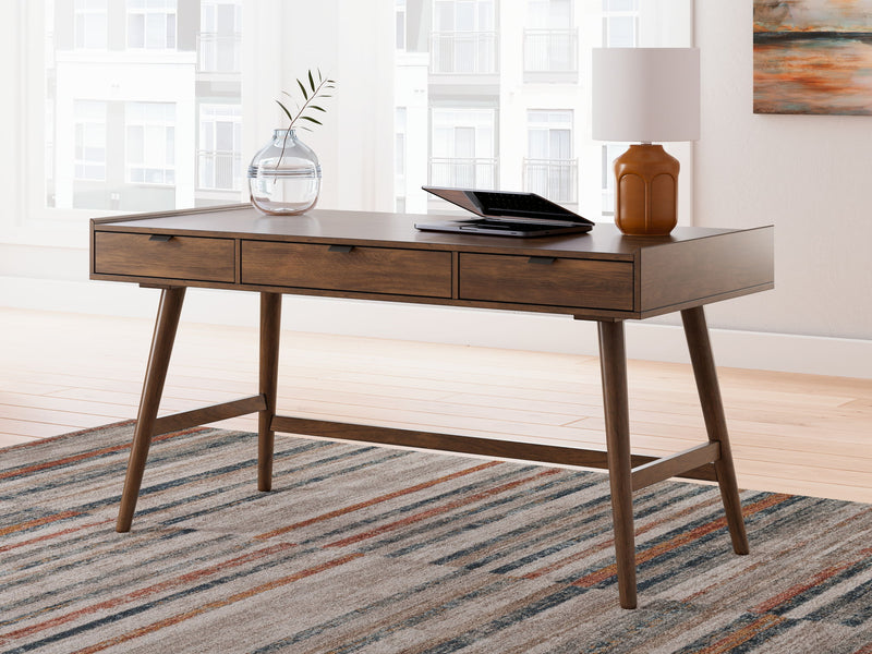 Signature Design by Ashley home office desk with a spacious wooden surface and sleek metal legs for writing and workspace.