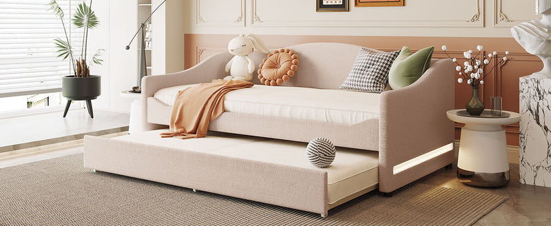 Light-colored upholstered daybed with built-in trundle and modern design, perfect for guest rooms or living spaces.