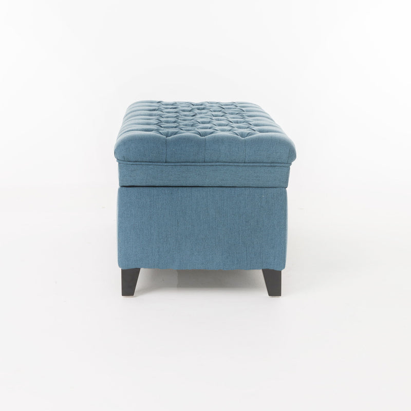 Noble House Juliana storage ottoman with birch wood legs, upholstered in neutral fabric, serving as a versatile seating and storage piece.