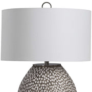 Gray and white Cyprien table lamp by Uttermost with a sleek, modern design featuring a smooth ceramic base and a fabric shade.