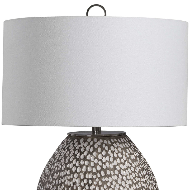 Gray and white Cyprien table lamp by Uttermost with a sleek, modern design featuring a smooth ceramic base and a fabric shade.