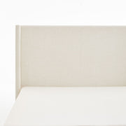 House & Home Furniture Hosford minimalist upholstered wingback bed with wood base platform, shown in neutral fabric and modern design.