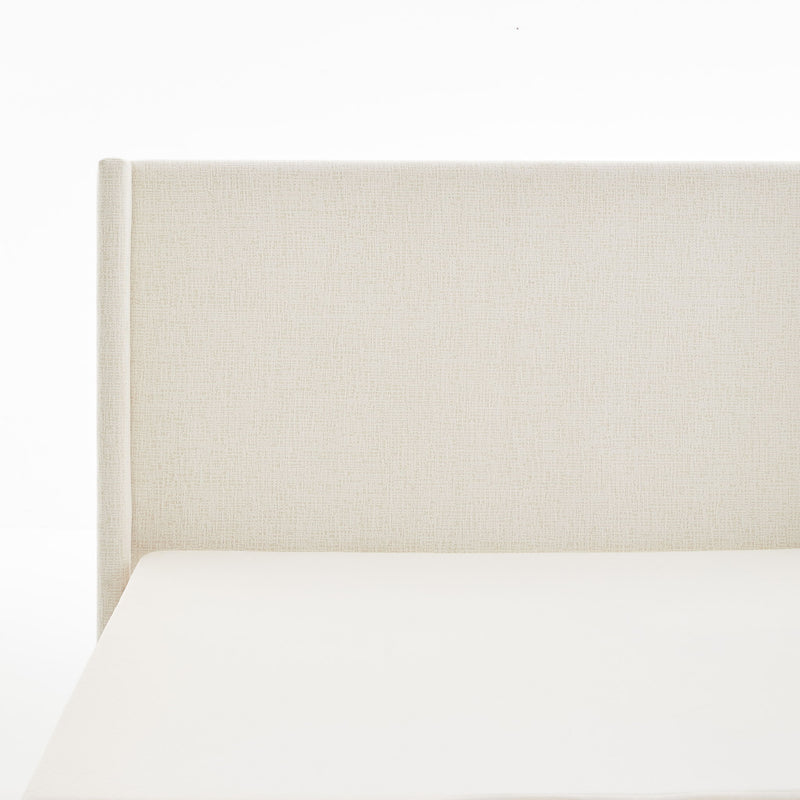 House & Home Furniture Hosford minimalist upholstered wingback bed with wood base platform, shown in neutral fabric and modern design.