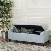 Noble House Guernsey storage ottoman with tufted top, beige fabric, and wooden legs, serving as stylish bedroom or living room storage.