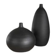 Set of two black Uttermost Bower vases with sleek, modern design, featuring smooth surfaces and elegant shapes.