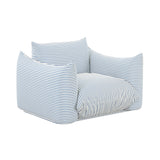 TOV Furniture Saint Tropez outdoor armchair with plush stuffed cushions, beige fabric, and sturdy wooden legs for patio relaxation.