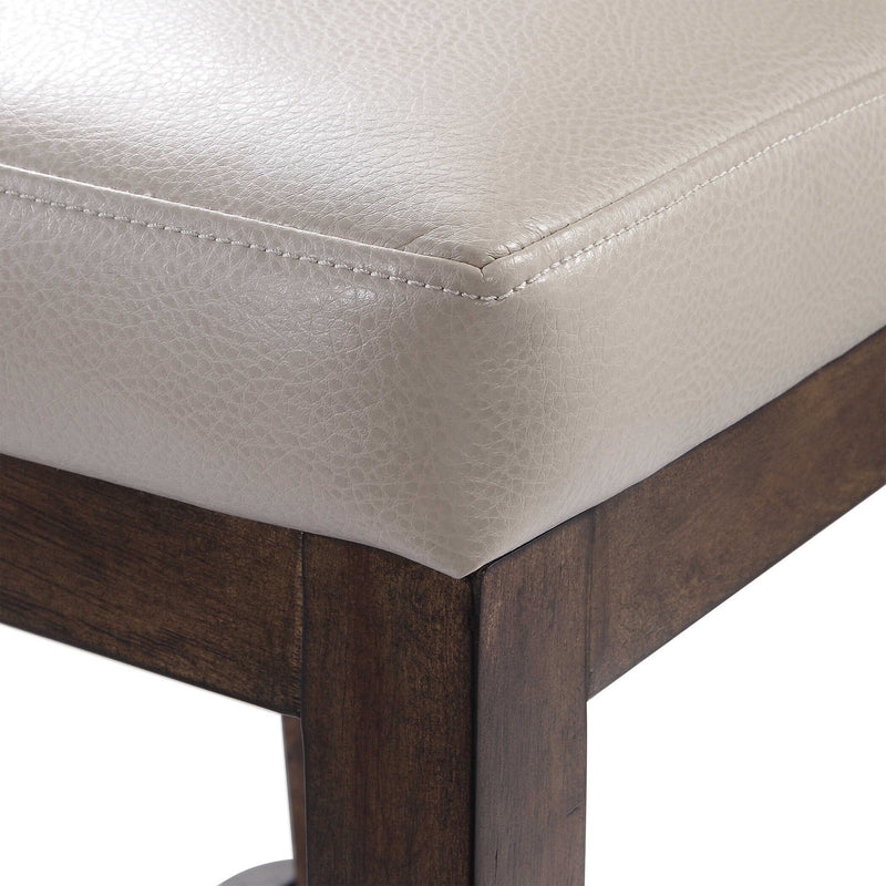 Uttermost Purcell beige counter stool with wooden legs and cushioned seat, ideal for kitchen or bar area, 24-27 inch height.