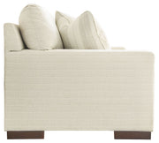 Signature Design by Ashley Maggie stationary sofa with plush cushions and neutral fabric, perfect for living room decor.
