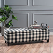 Black Noble House storage ottoman with cushioned top and interior storage, serving as seating and a functional living room accent.
