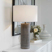 Gray Monolith table lamp by Uttermost featuring a sleek, modern design with a cylindrical base and a fabric lampshade.