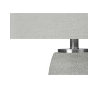 Gray ceramic table lamp by 8th Street with modern design, featuring a smooth, rounded shape and a fabric lampshade.