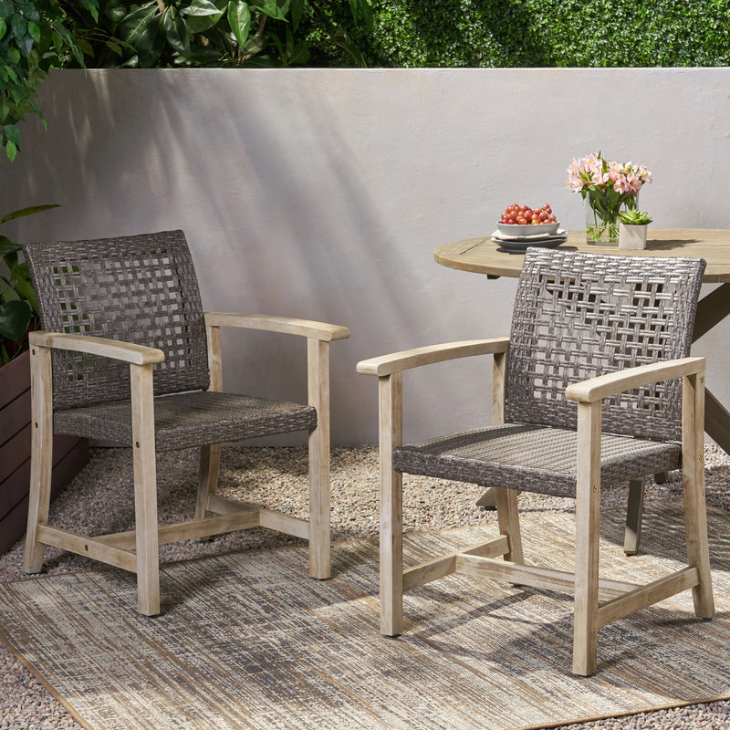 Set of two Noble House outdoor dining chairs with acacia wood frames, featuring slatted seats and armrests for patio dining.