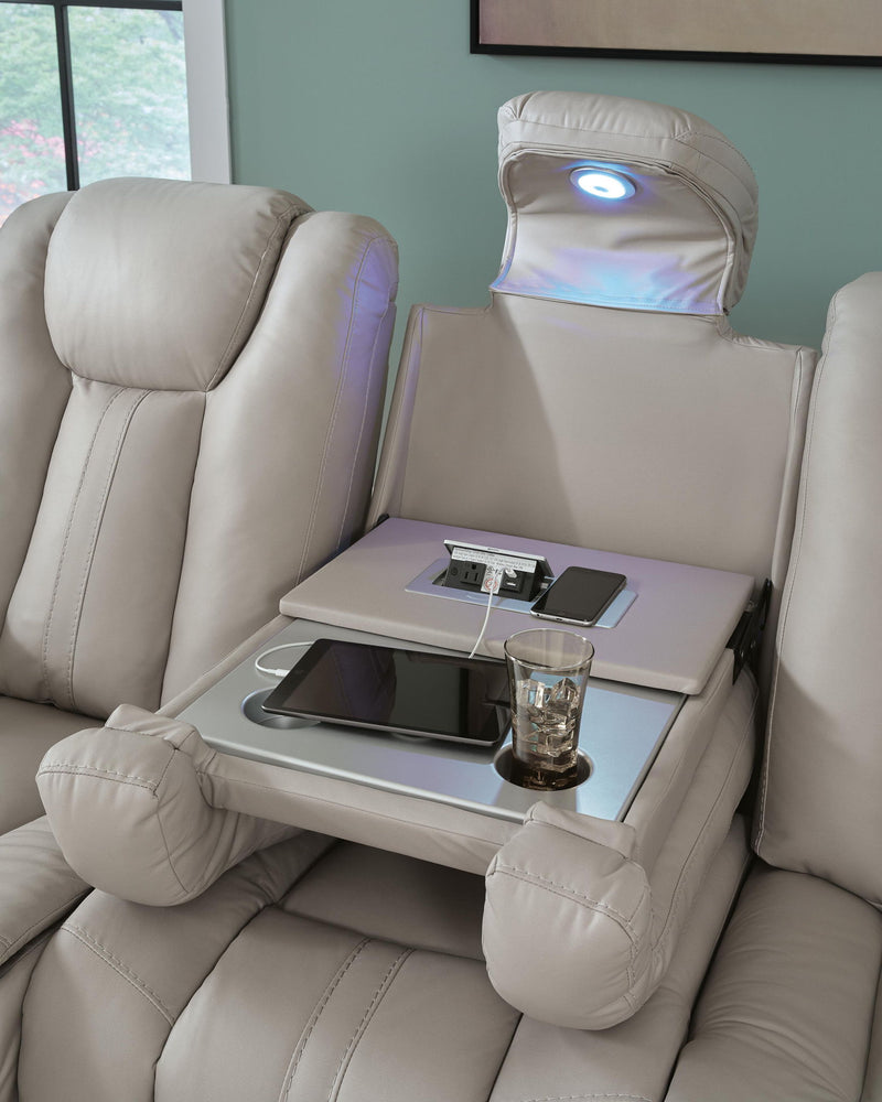 Signature Design by Ashley Elevate Edges reclining sofa with drop-down table in coin fabric, featuring plush cushions and armrests.