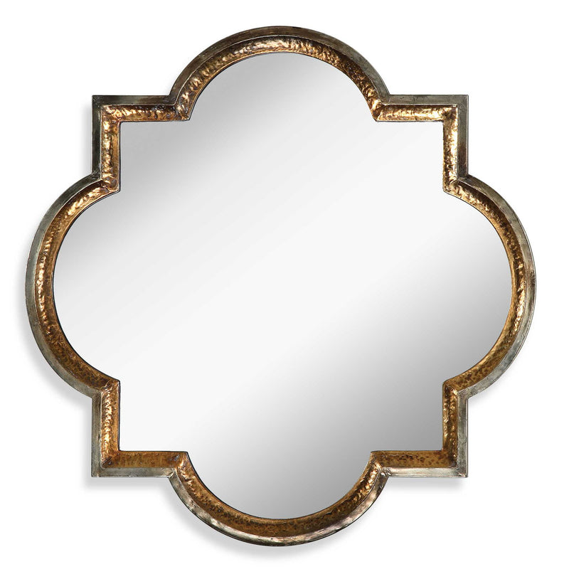 Uttermost Lourosa gold wall mirror with a round, decorative frame, hanging on a wall, reflecting a modern interior.