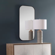 Uttermost Taft wall mirror with a sleek, modern frame, hanging on a wall, showcasing reflective glass and stylish design.