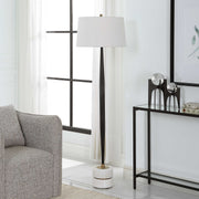 Uttermost Miraz black floor lamp with a sleek, modern design and tall, slender profile standing on a neutral floor.