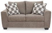 Benchcraft® Loreo stationary loveseat with plush fabric and cushioned arms, ideal for cozy living room seating.