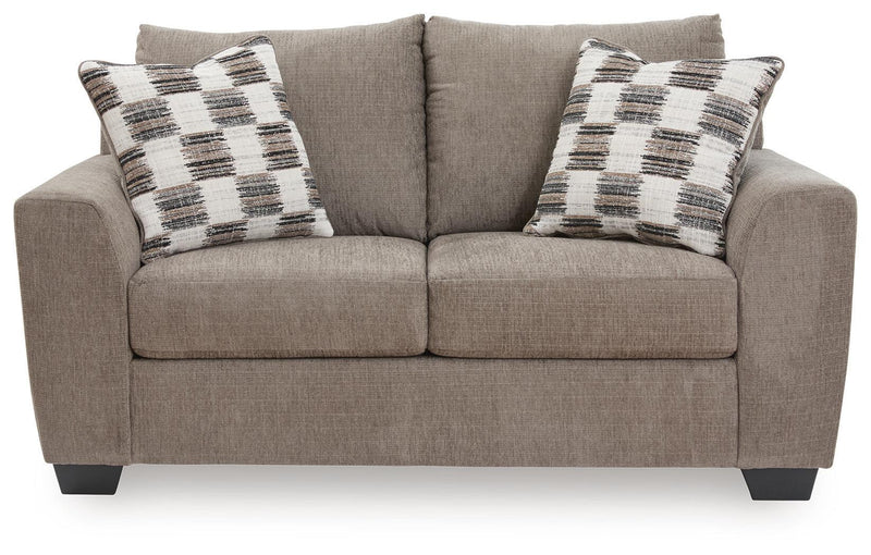Benchcraft® Loreo stationary loveseat with plush fabric and cushioned arms, ideal for cozy living room seating.