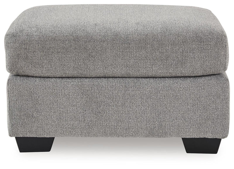 Benchcraft® upholstered Ottoman with plush fabric and tufted top, perfect for living room or bedroom decor.