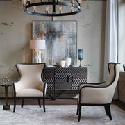 Uttermost Sandy wing back armchair in beige and dark brown fabric with plush cushioning and curved wooden legs.