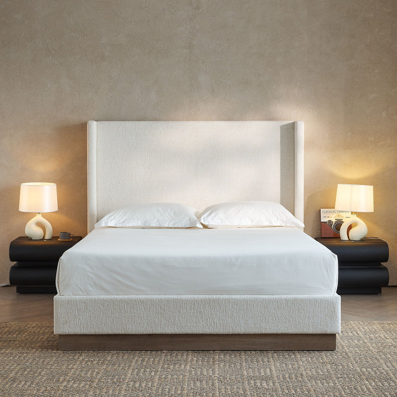House & Home Furniture Hosford minimalist upholstered wingback bed with wood base platform, shown in a modern bedroom setting.