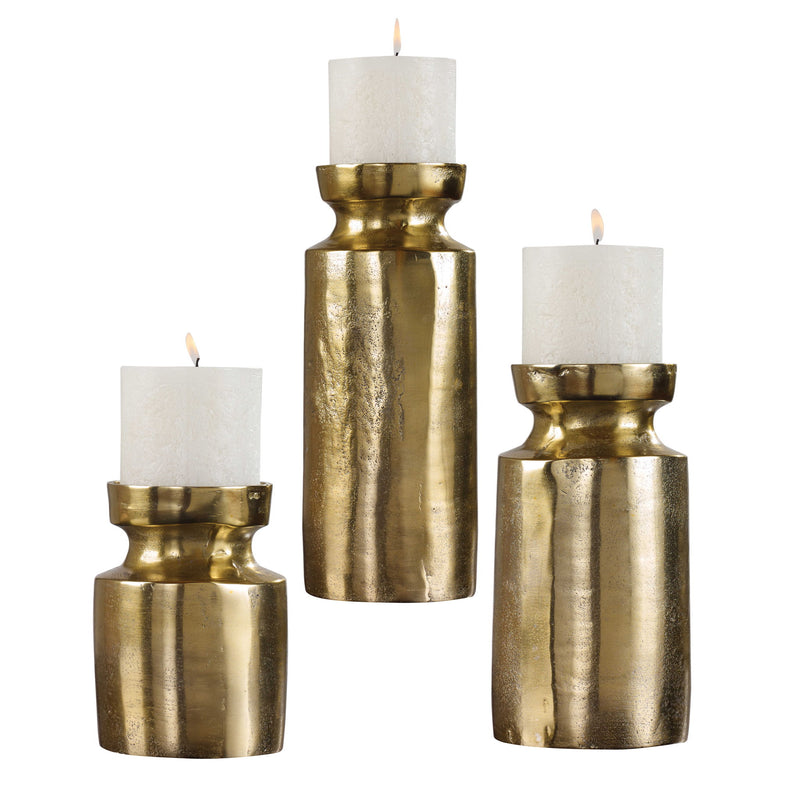 Set of three Amina candleholders in antique brass by Uttermost, featuring elegant sculpture-style design for decorative use.