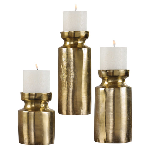Set of three Amina candleholders in antique brass by Uttermost, featuring elegant sculpture-style design for decorative use.