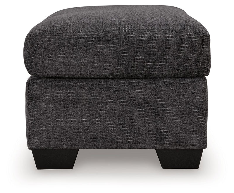 Upholstered Ottoman by Benchcraft® featuring a cushioned top and wooden legs, ideal for living room or lounge decor.