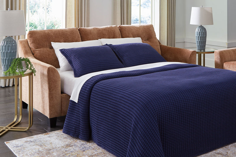 Benchcraft® Amity Bay sofa chaise sleeper with plush fabric, featuring a convertible design and comfortable seating.