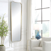 Large wall mirror by Uttermost in antique brass finish, featuring a sleek, modern design with a rectangular frame.
