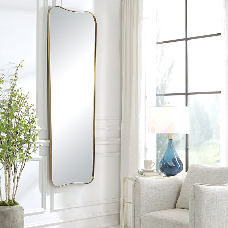 Large wall mirror by Uttermost in antique brass finish, featuring a sleek, modern design with a rectangular frame.