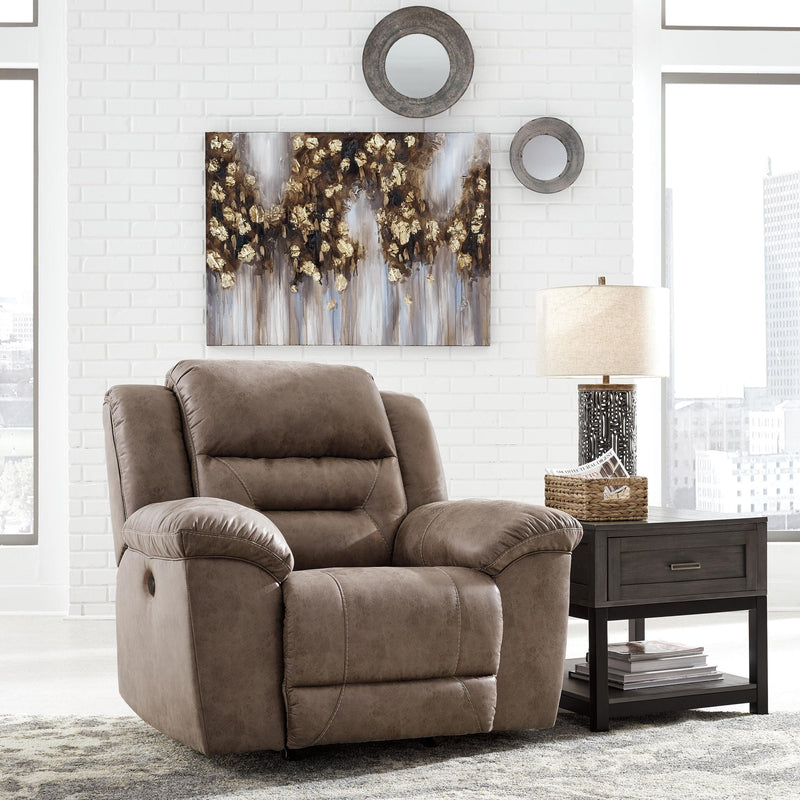 Signature Design by Ashley Stoneland power recliner rocker chair with plush cushioning and modern design, shown in a cozy living room setting.