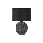 Contemporary black ceramic table lamp by 8th Street with a sleek, modern design and a smooth, rounded base.