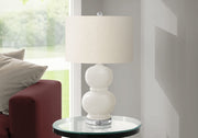 Modern 8th Street contemporary table lamp with sleek design and neutral-colored shade on a wooden table.
