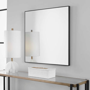 Uttermost Alexo square wall mirror with a sleek, modern frame hanging on a wall, showcasing contemporary home decor.