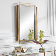 Uttermost Amherst wall mirror with a sleek, modern frame, hanging on a wall in a contemporary interior.